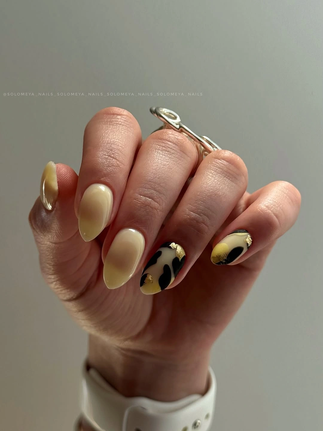 Rounded yellow green nails with dark botanical accents