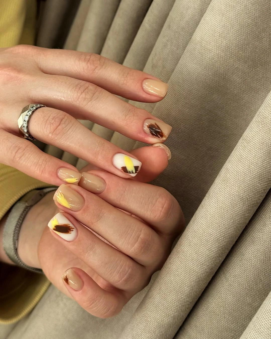 Short nude nails with tiny colorful accent motifs