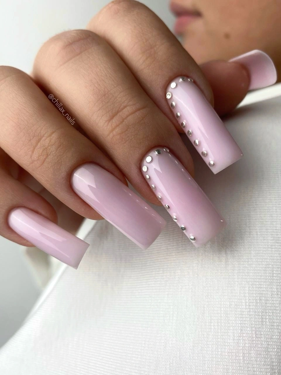 long square pale pink nails with white and pearl-like accents