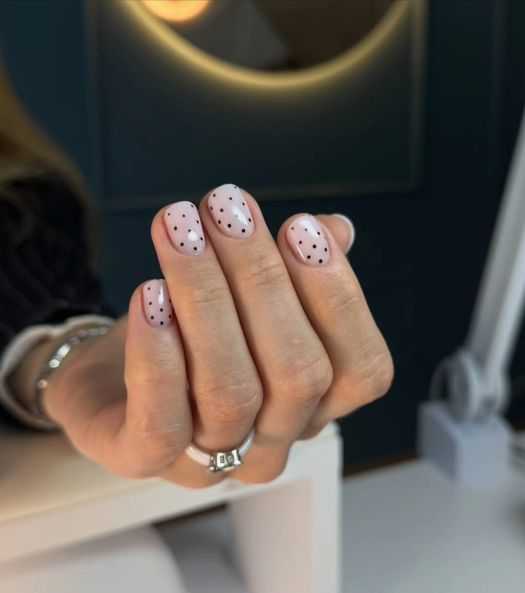 medium square pale pink nails with fine dark speckles