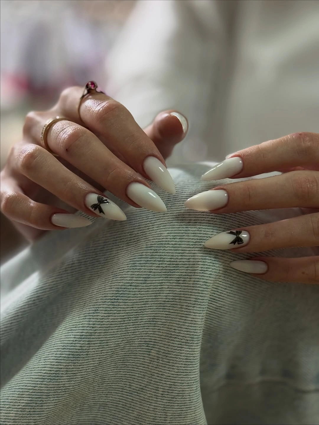 Cream almond nails with tiny black bows
