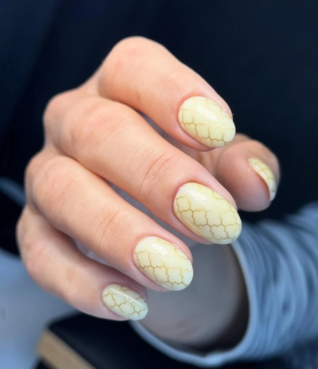 Pale yellow almond nails with fine gold pattern