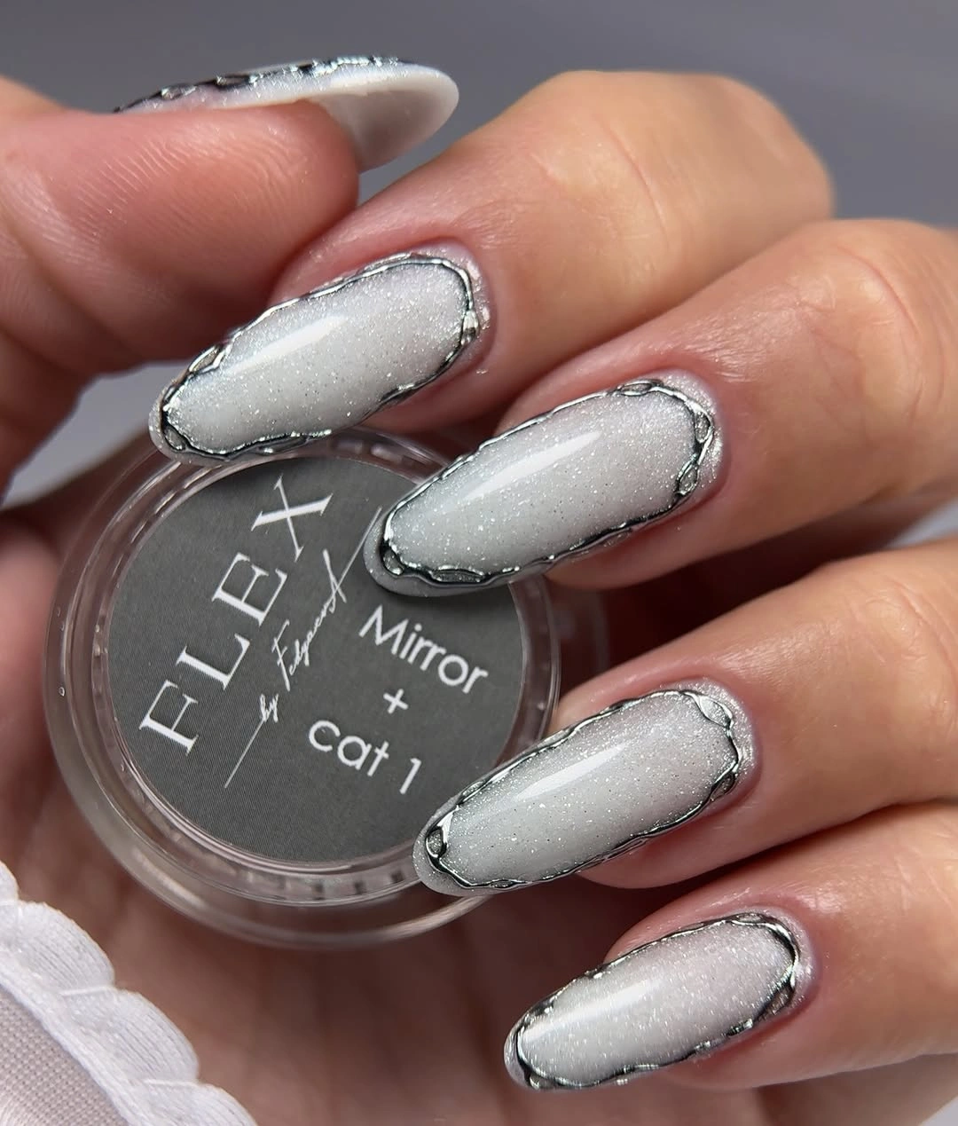 Pearl white almond nails with silver borders