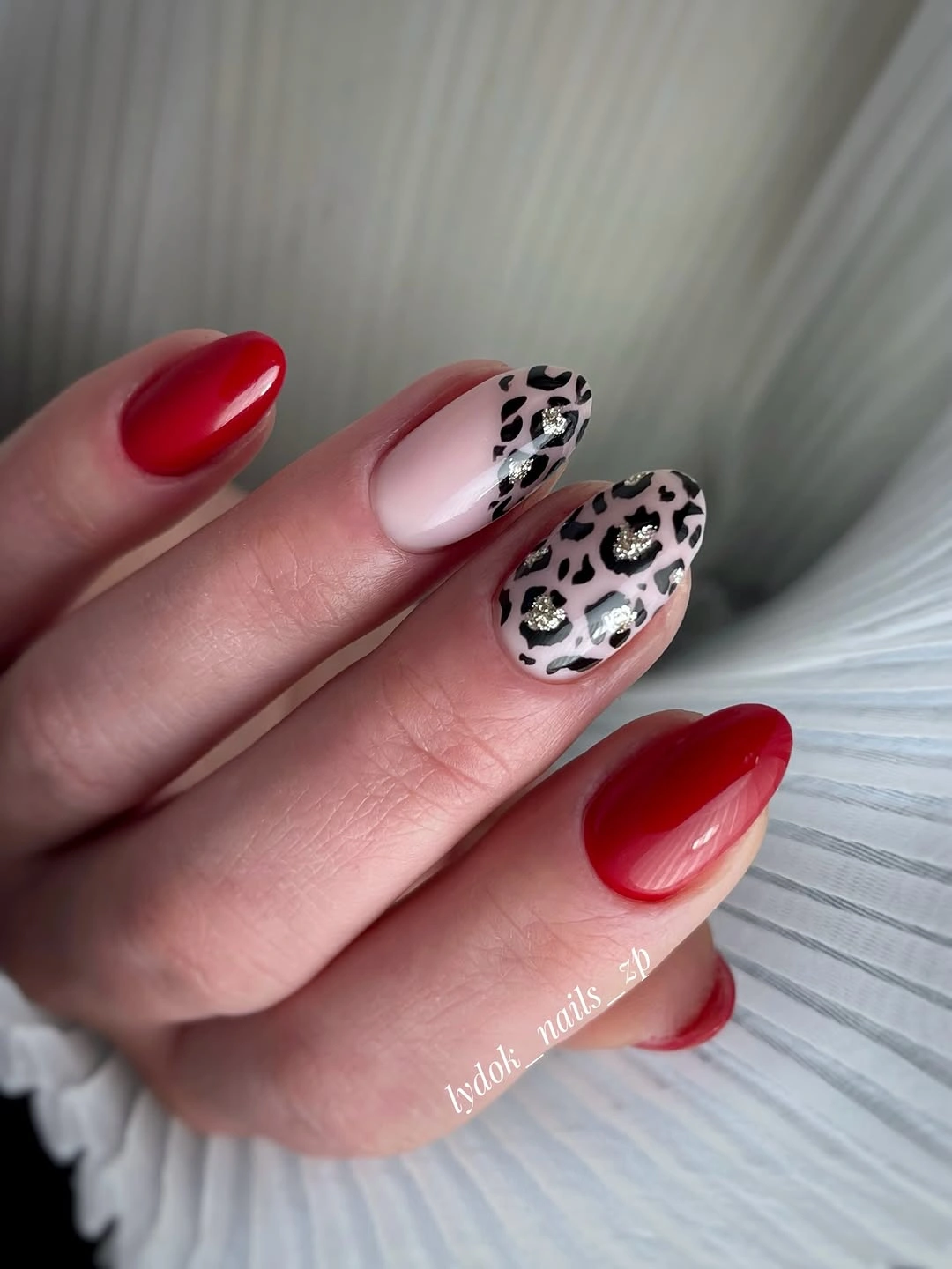 Red nails with leopard accent design