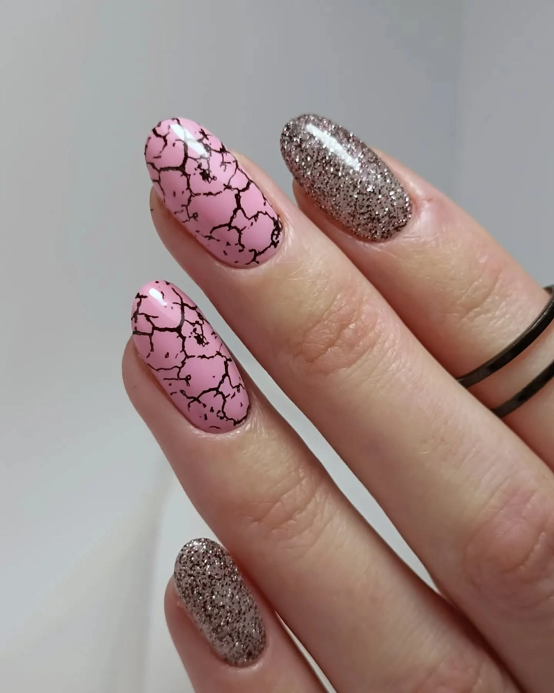 long almond pink nails with black crackle lines and sparkle