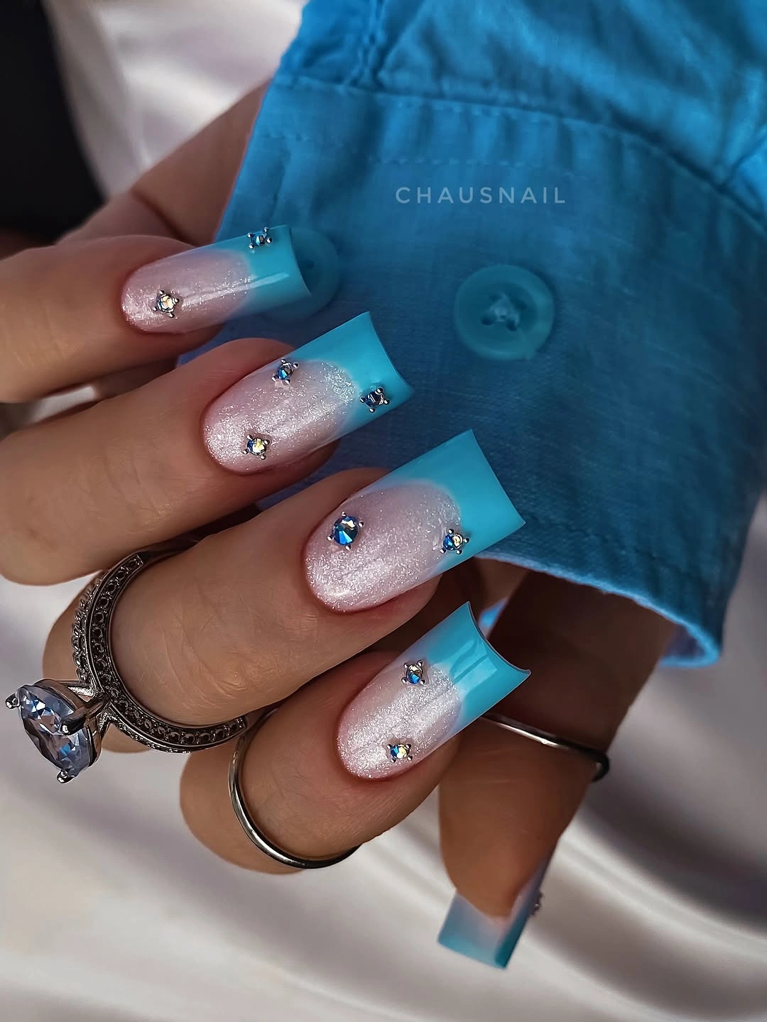 long square pale pink nails with bright blue edges and shimmer