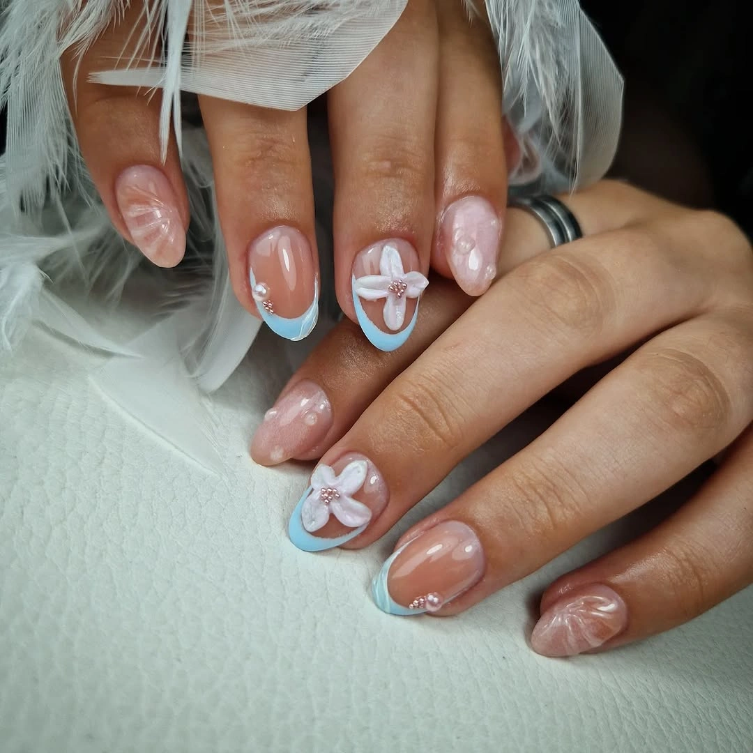 Glossy nude-pink nails with small white floral accents