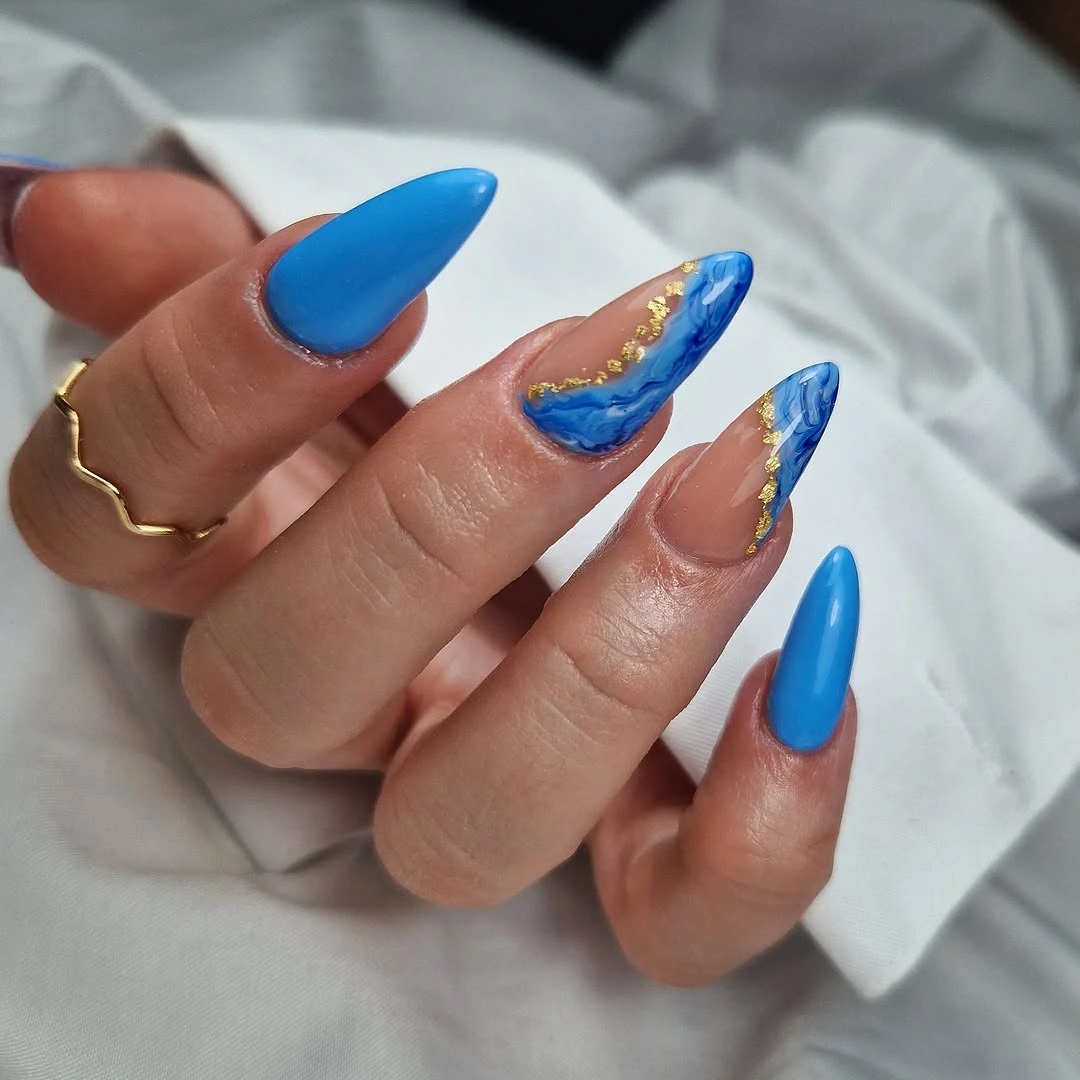 Long vivid blue nails with pale and warm metallic accents