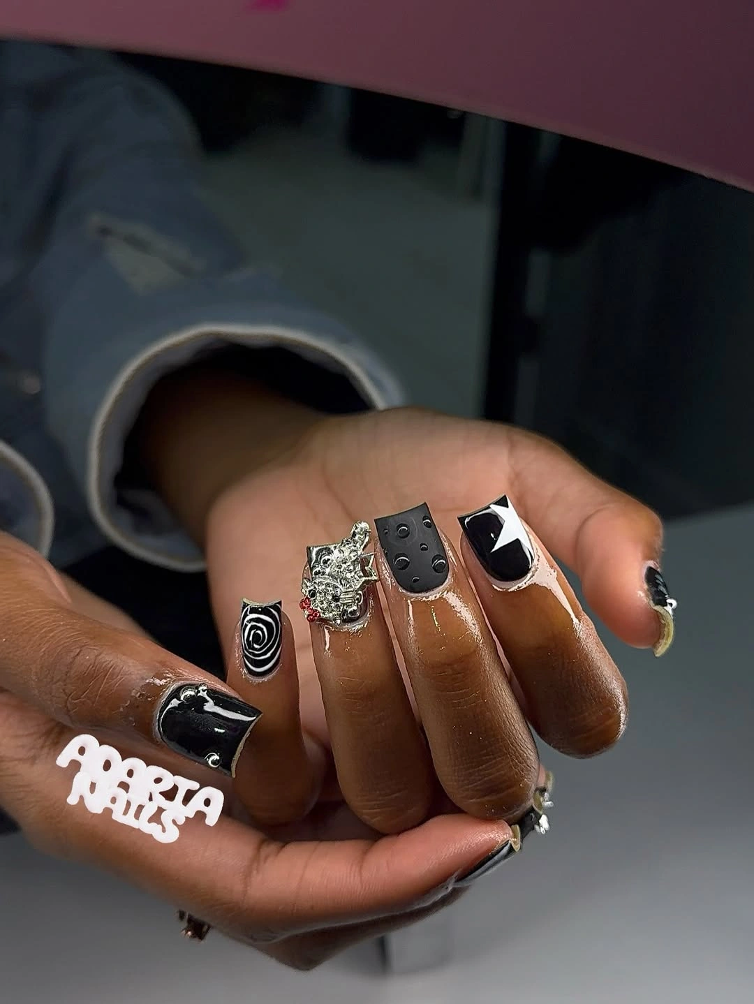 Mixed black and white nails with one reflective focal accent