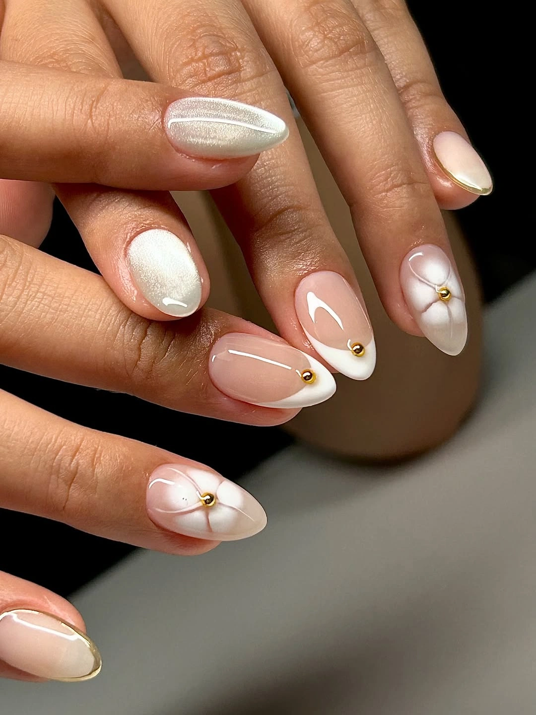 Milky pink almond nails with white curves and gold points