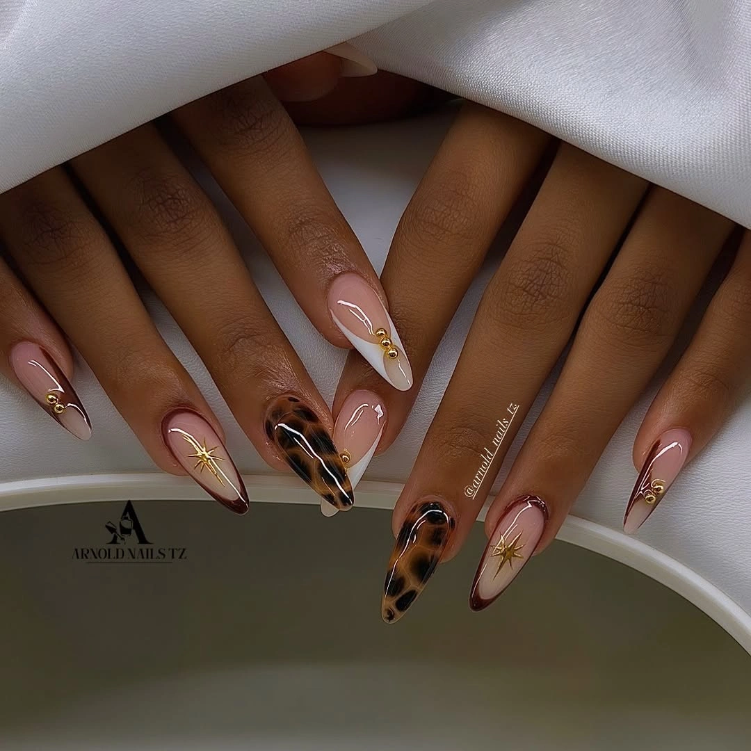 Long almond nude nails with brown marbled gold accents