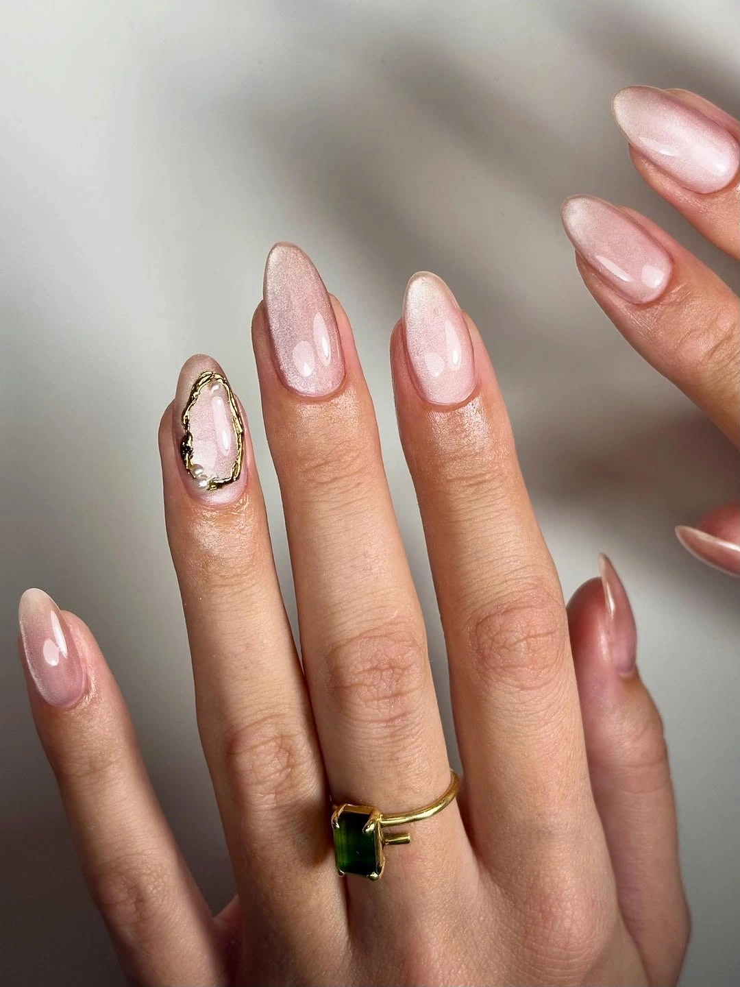 Pale pink almond nails with one small gold framed accent