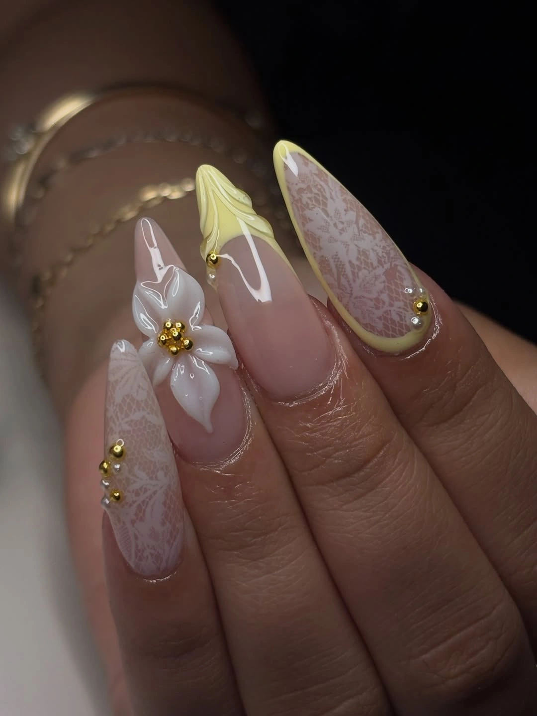 Pale yellow almond nails with white flower accent