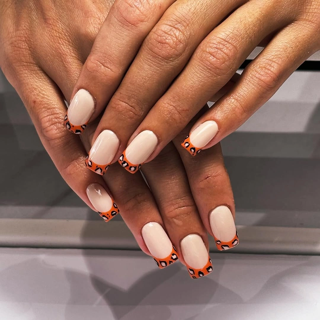 Short cream square nails with orange printed tips