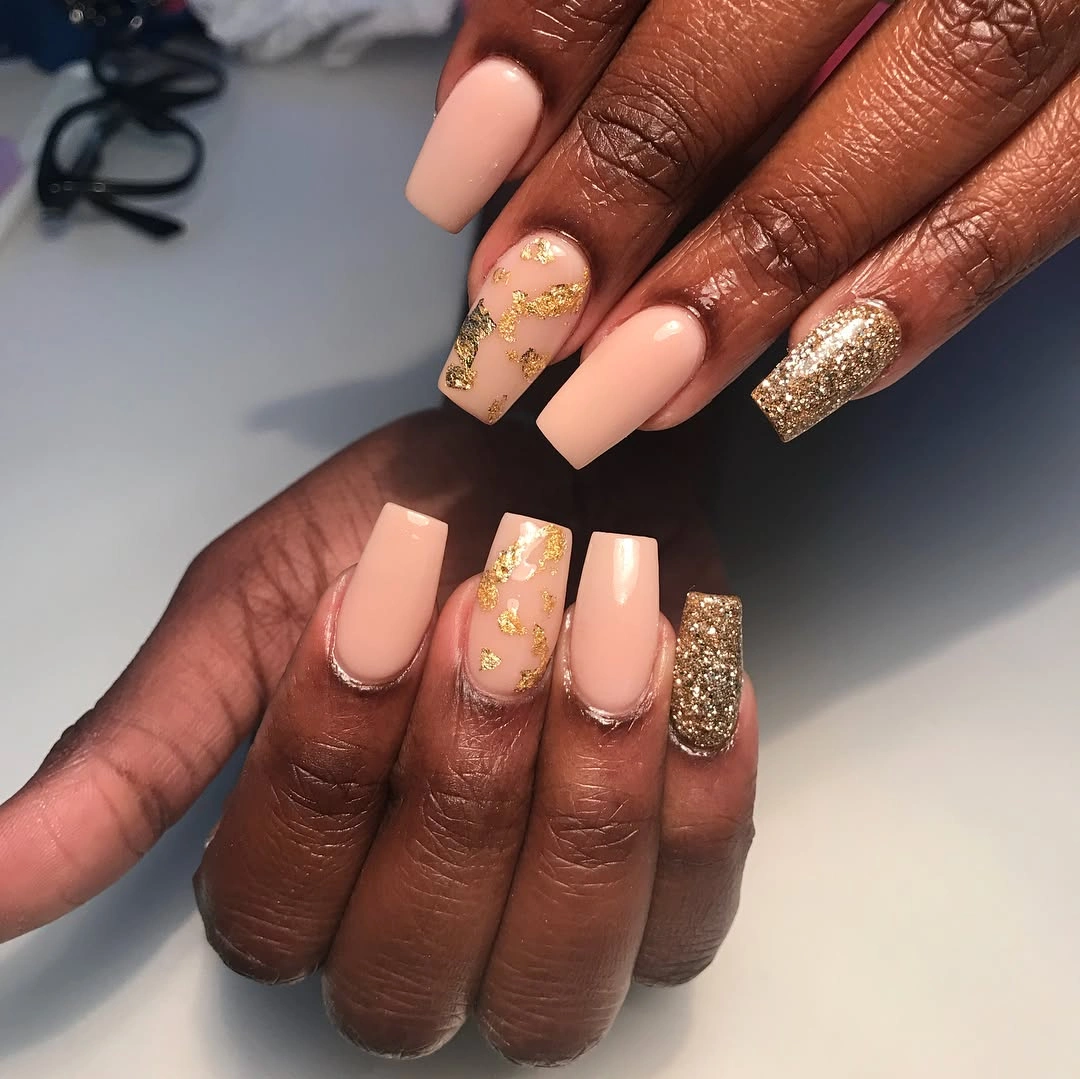 Long nude square nails with gold glitter accents