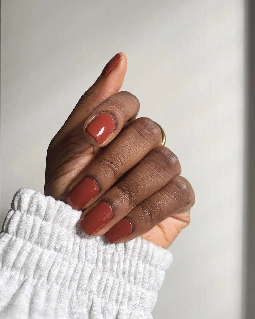 Short rounded square nails in glossy terracotta polish