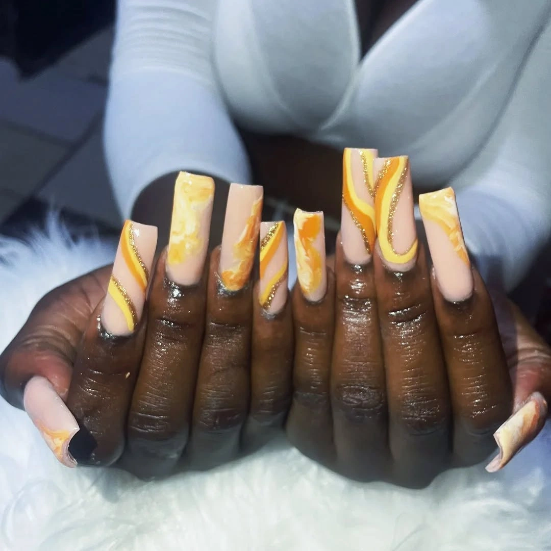 Long coffin nails with yellow orange marble and gold waves