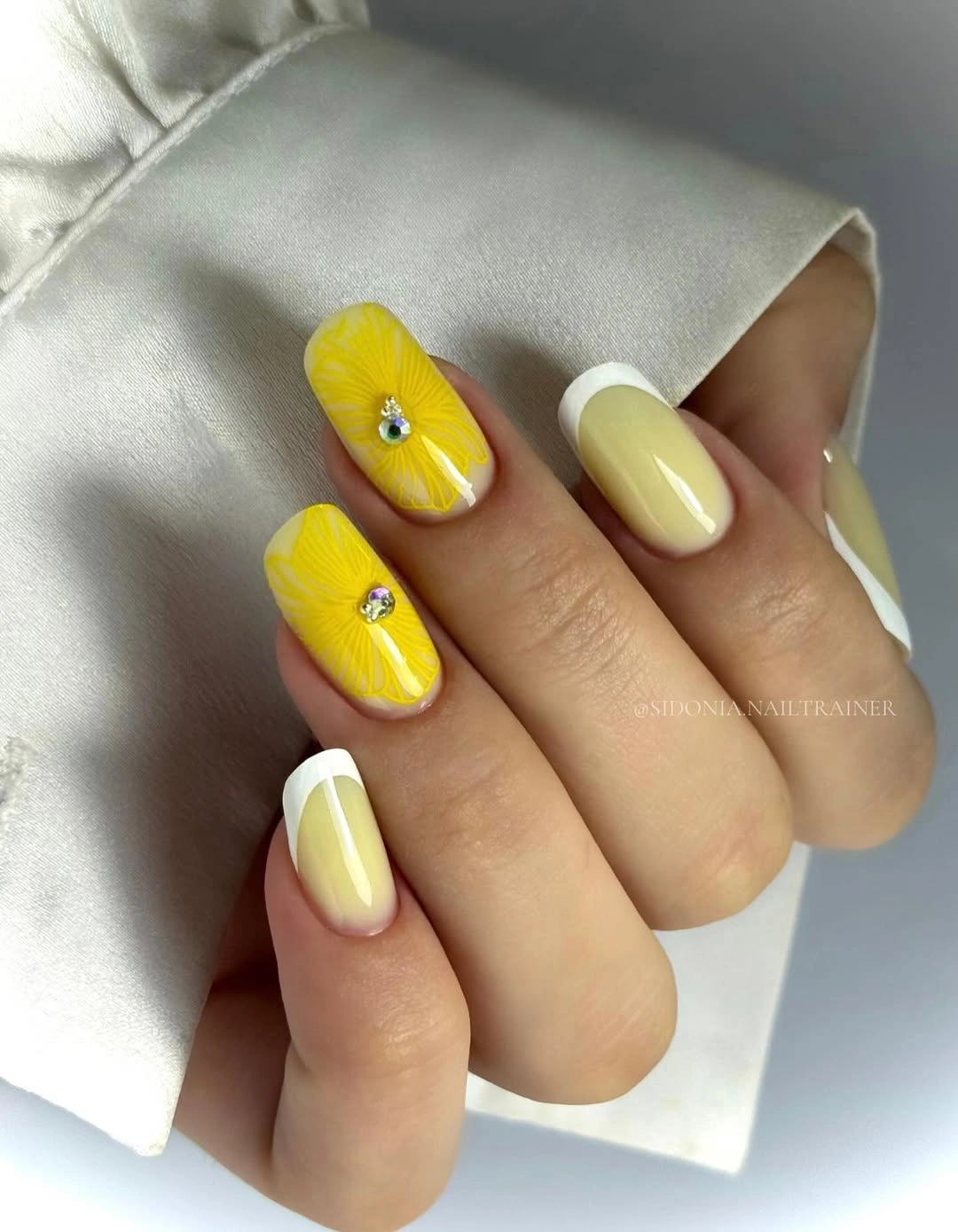 Creamy rounded nails with bright yellow floral accents