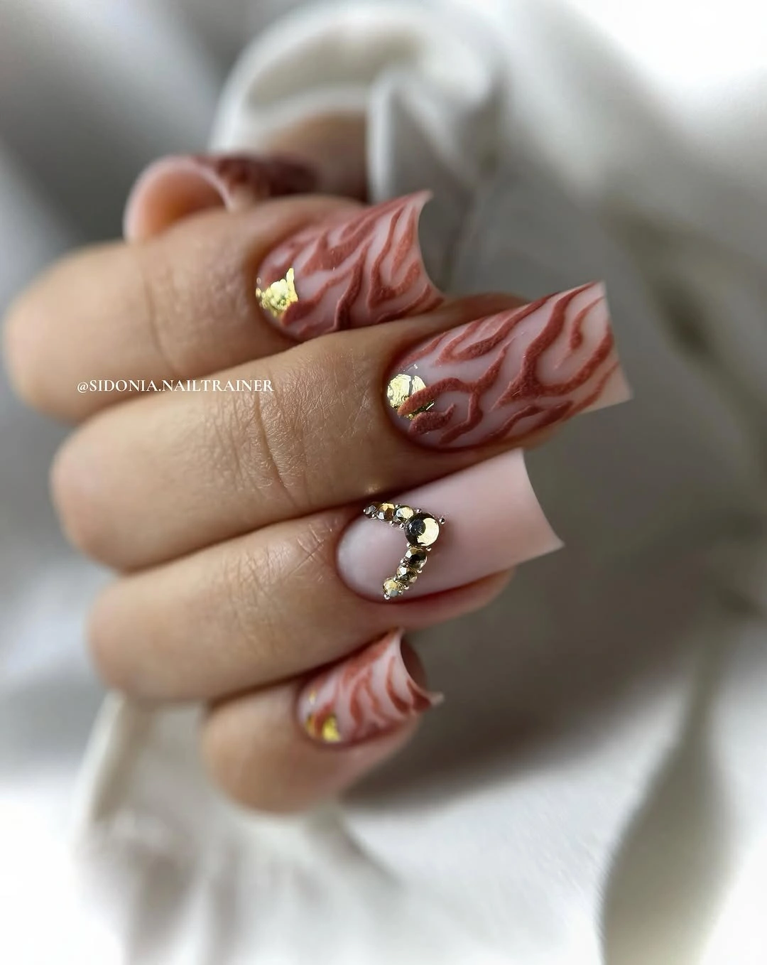Long square nude nails with flowing brown wave details