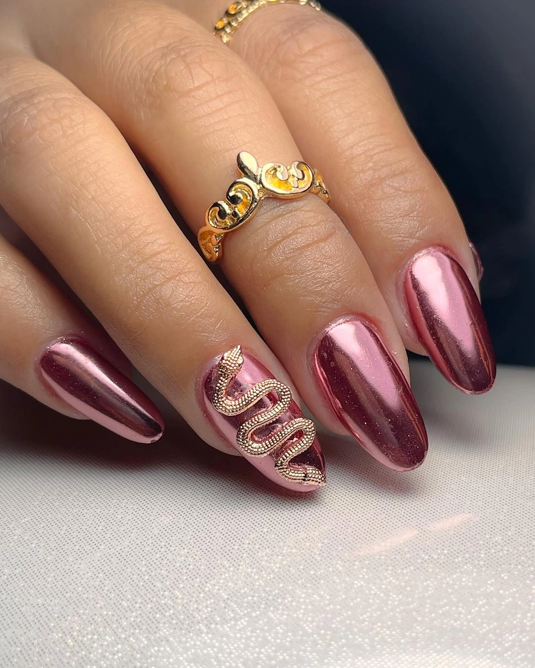 Rose metallic almond nails with one bold gold loop accent