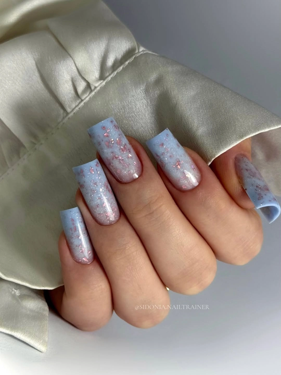 Pale blue square nails with sparse pink glitter flecks