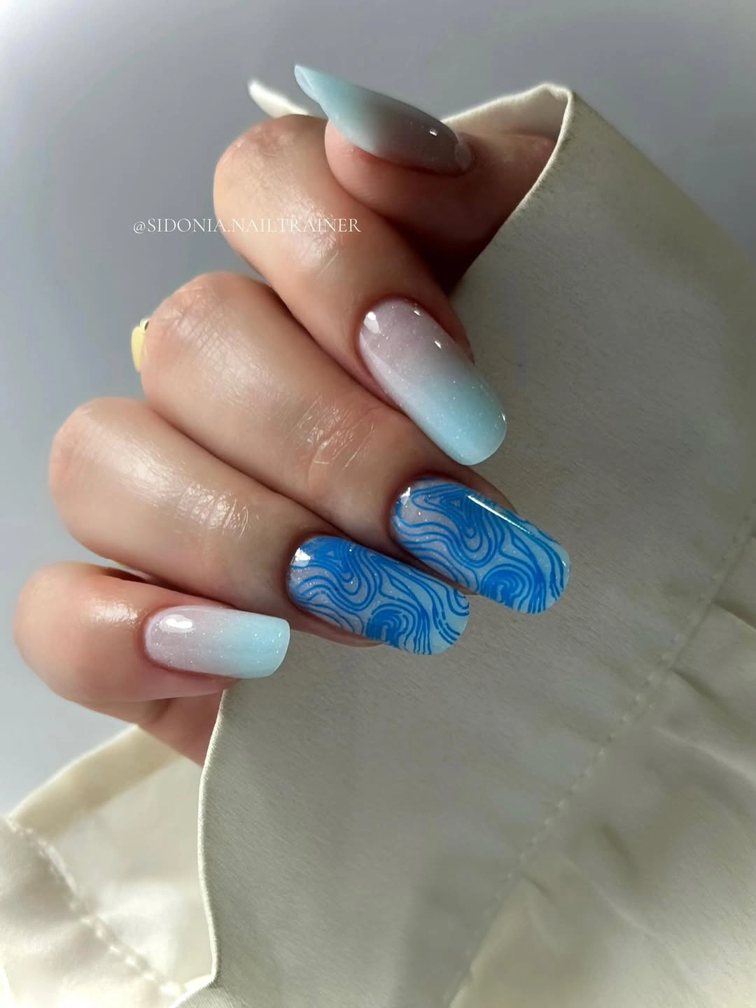 Almond nails with white aqua gradient and blue swirls
