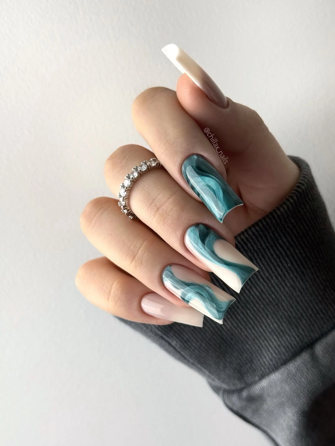 long pale nails with turquoise curved accent sections
