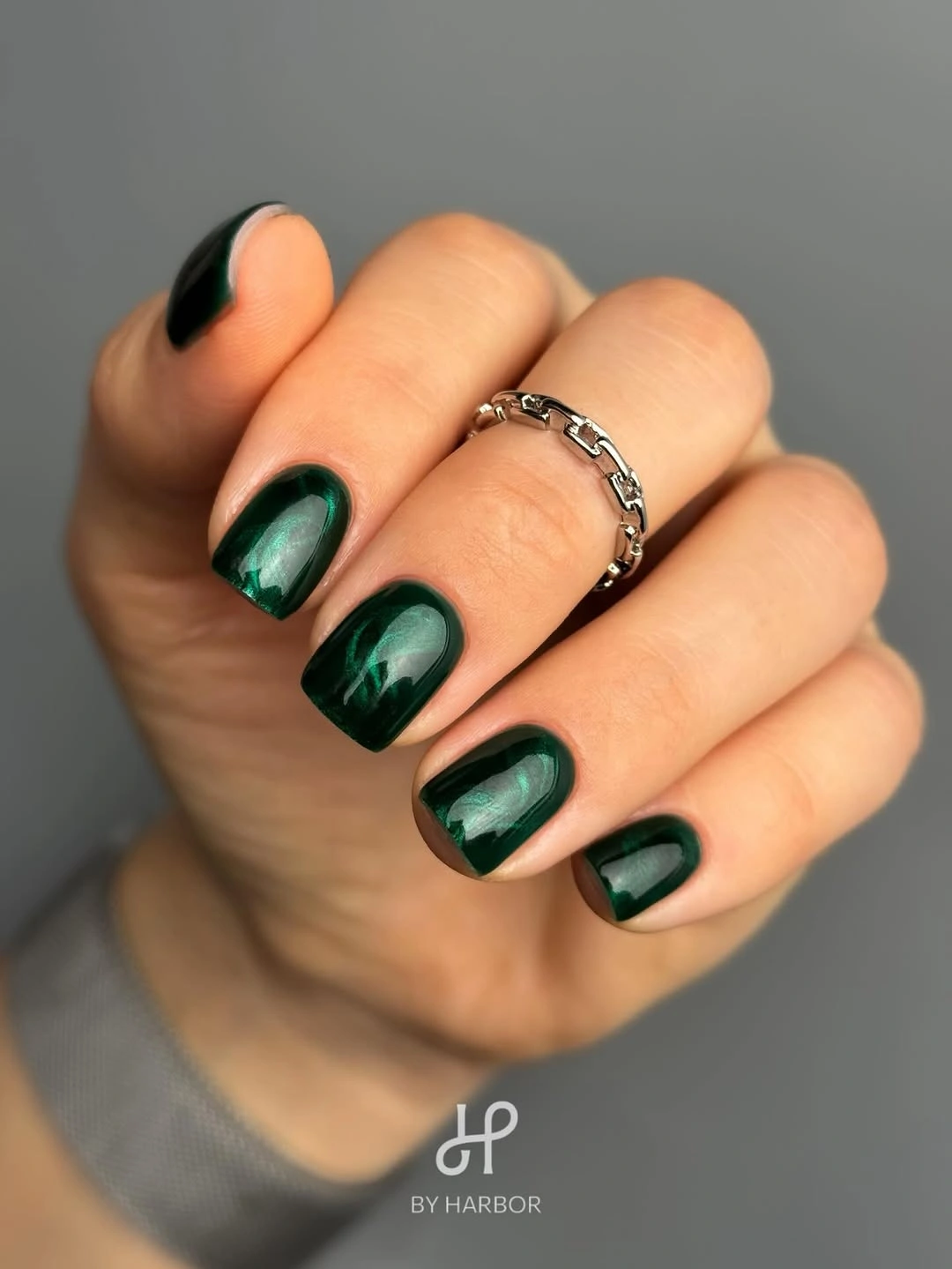 short deep emerald nails with subtle reflective green variation