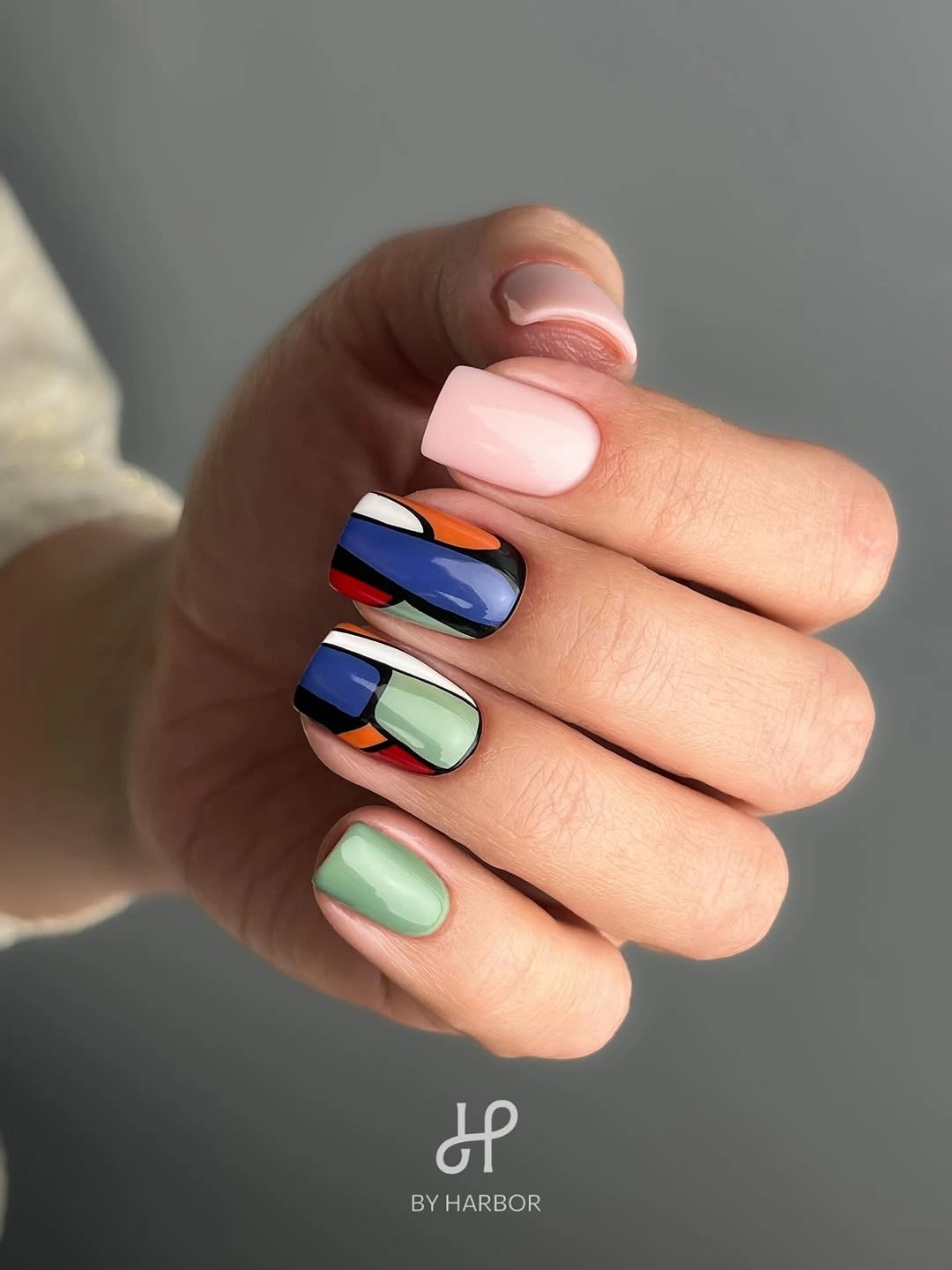 short pink nails with separate blue red green and black color panels