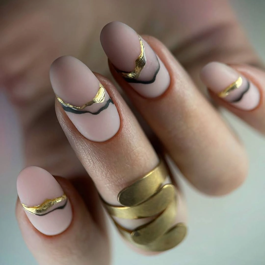 nude pink square nails with outlined black and gold curved tips