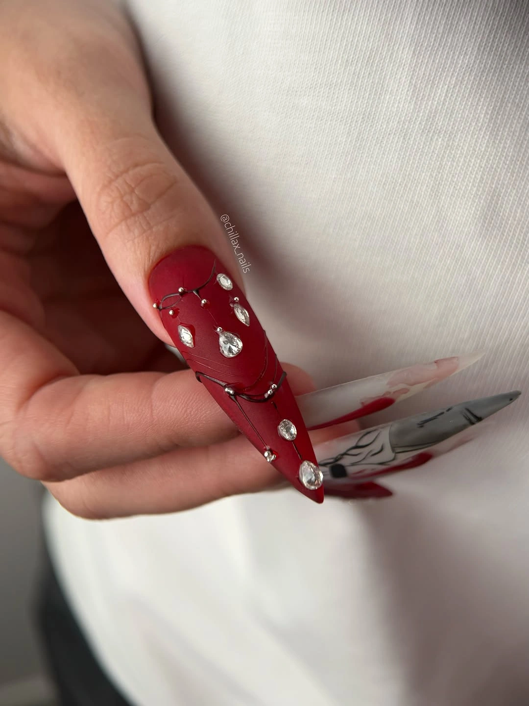 long red square nails with narrow pale and metallic-looking accents
