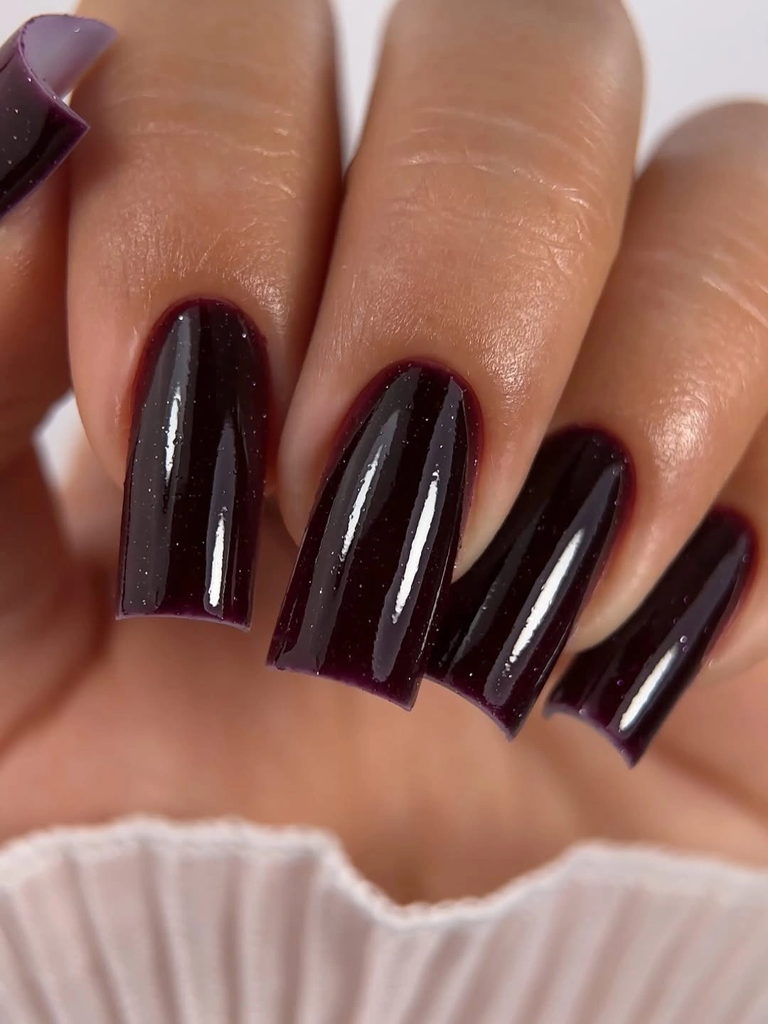 glossy blackened burgundy nails on a medium square silhouette