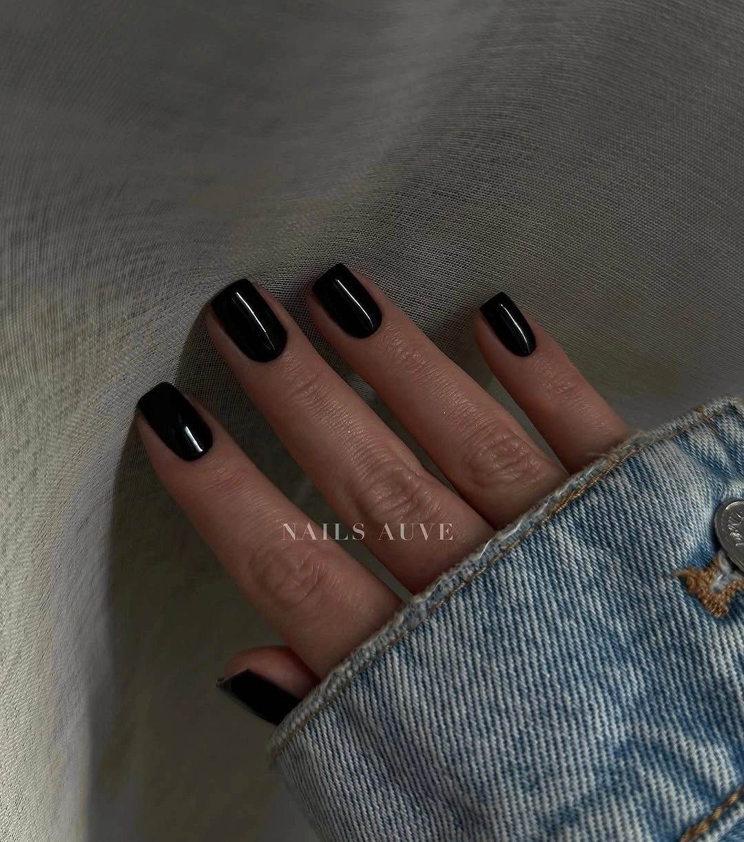 Short glossy black squoval nails with a clean outline