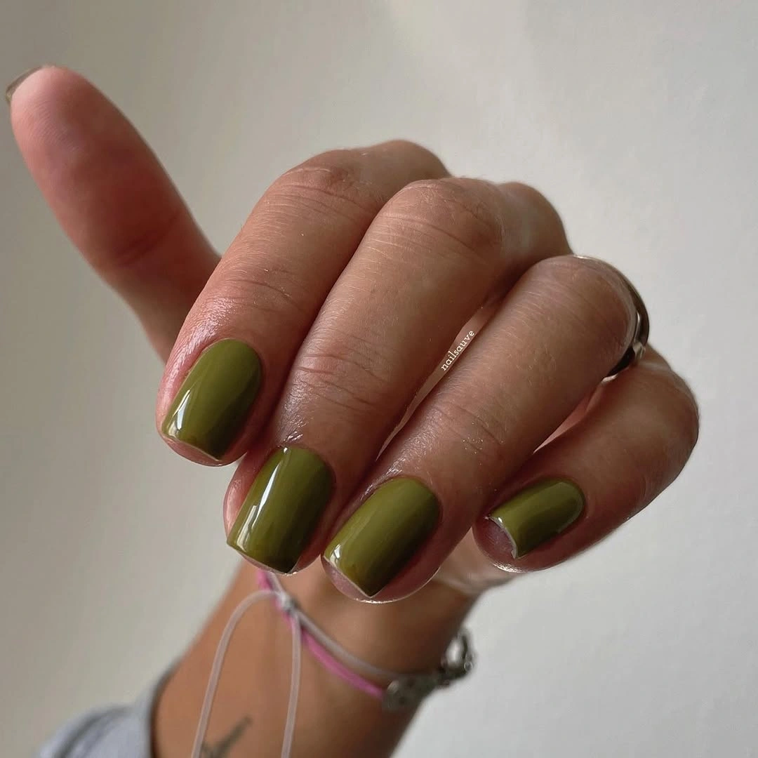 Short rounded olive green nails in a glossy solid shade