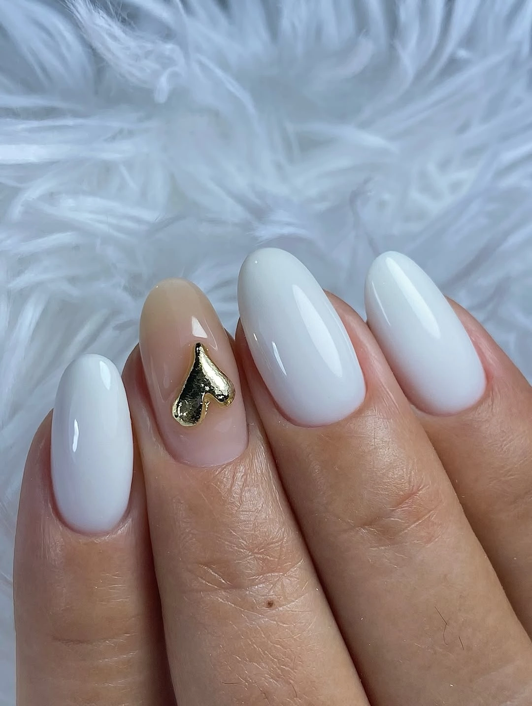 Milky white almond nails with one small gold heart accent