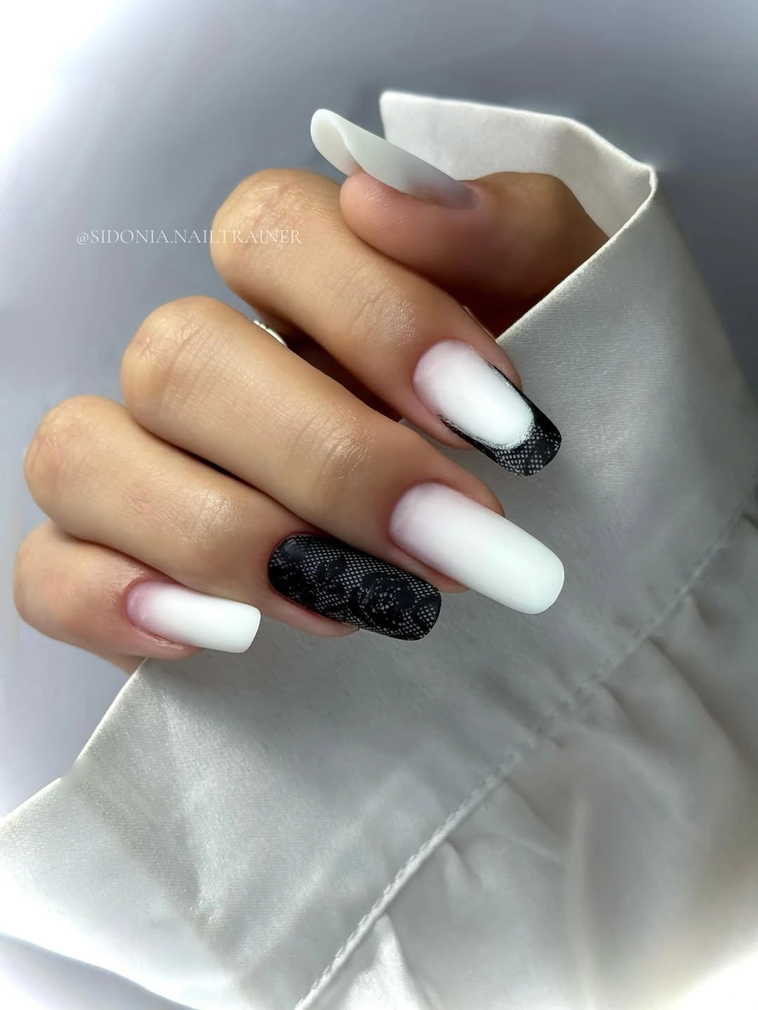 Long white square nails with black textured accents