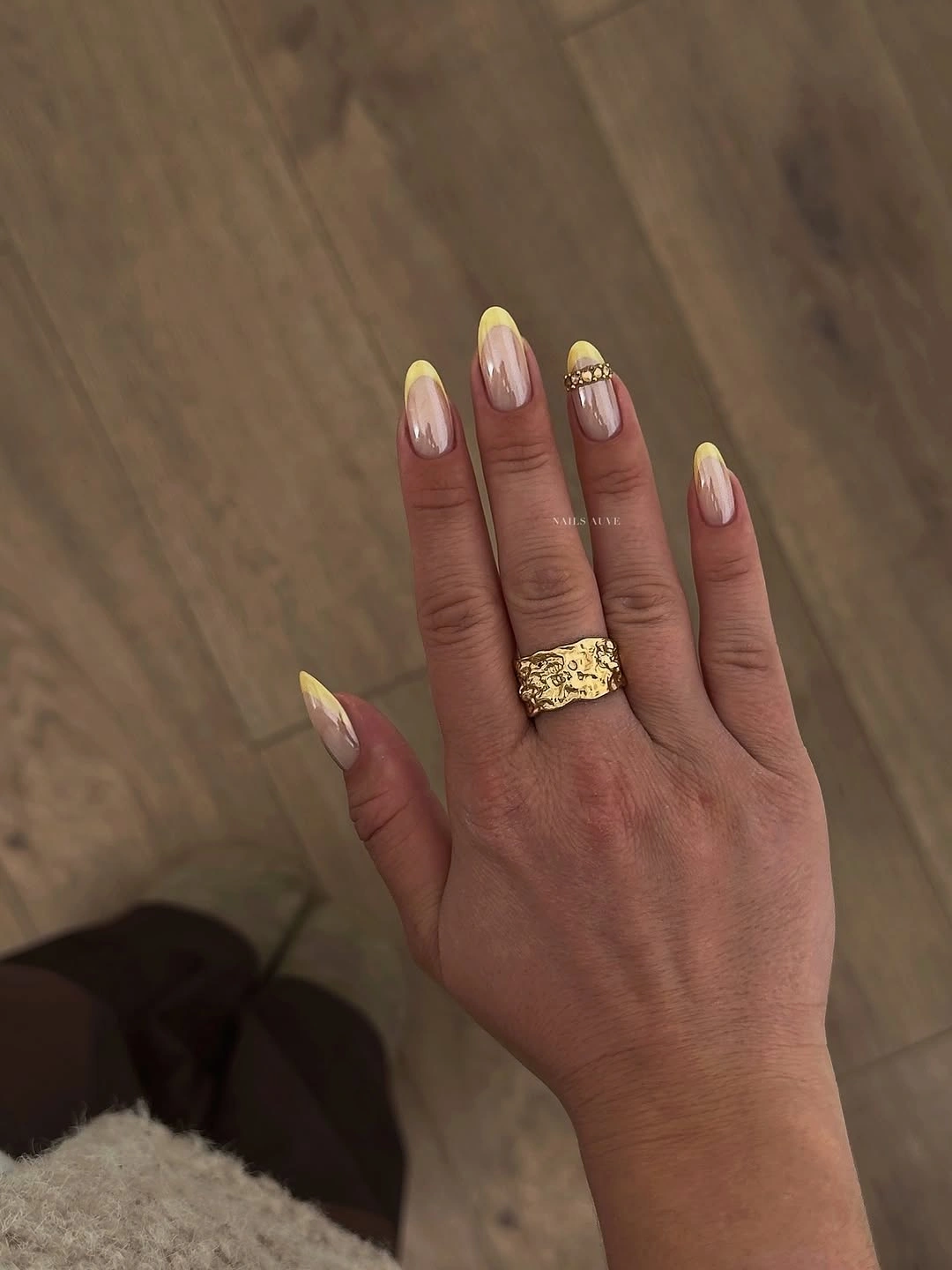 Nude almond nails with bright yellow French tips