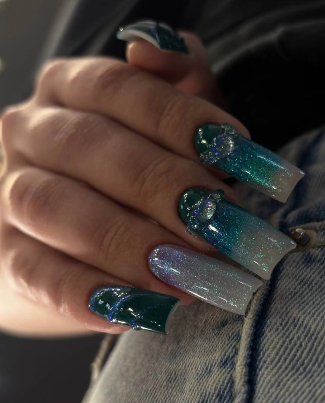 long deep teal nails with a concentrated blue-green glitter accent