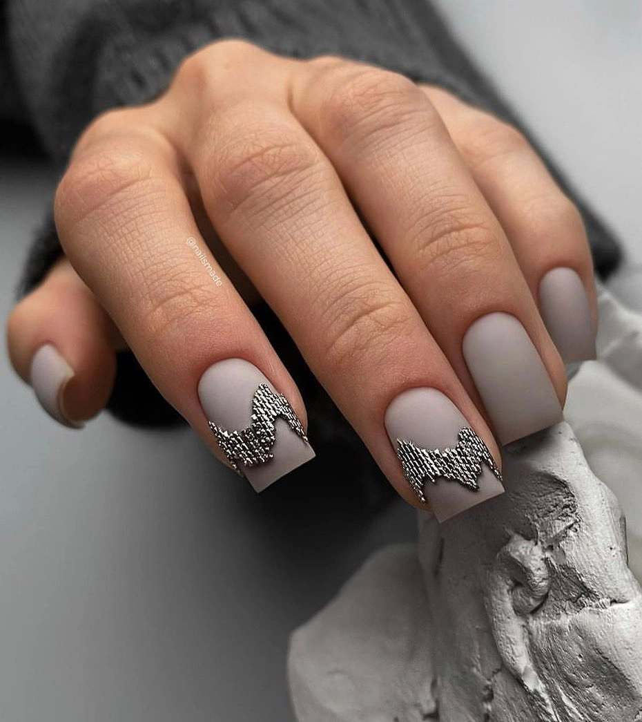 soft gray-lilac nails with a black and silver loop-like accent