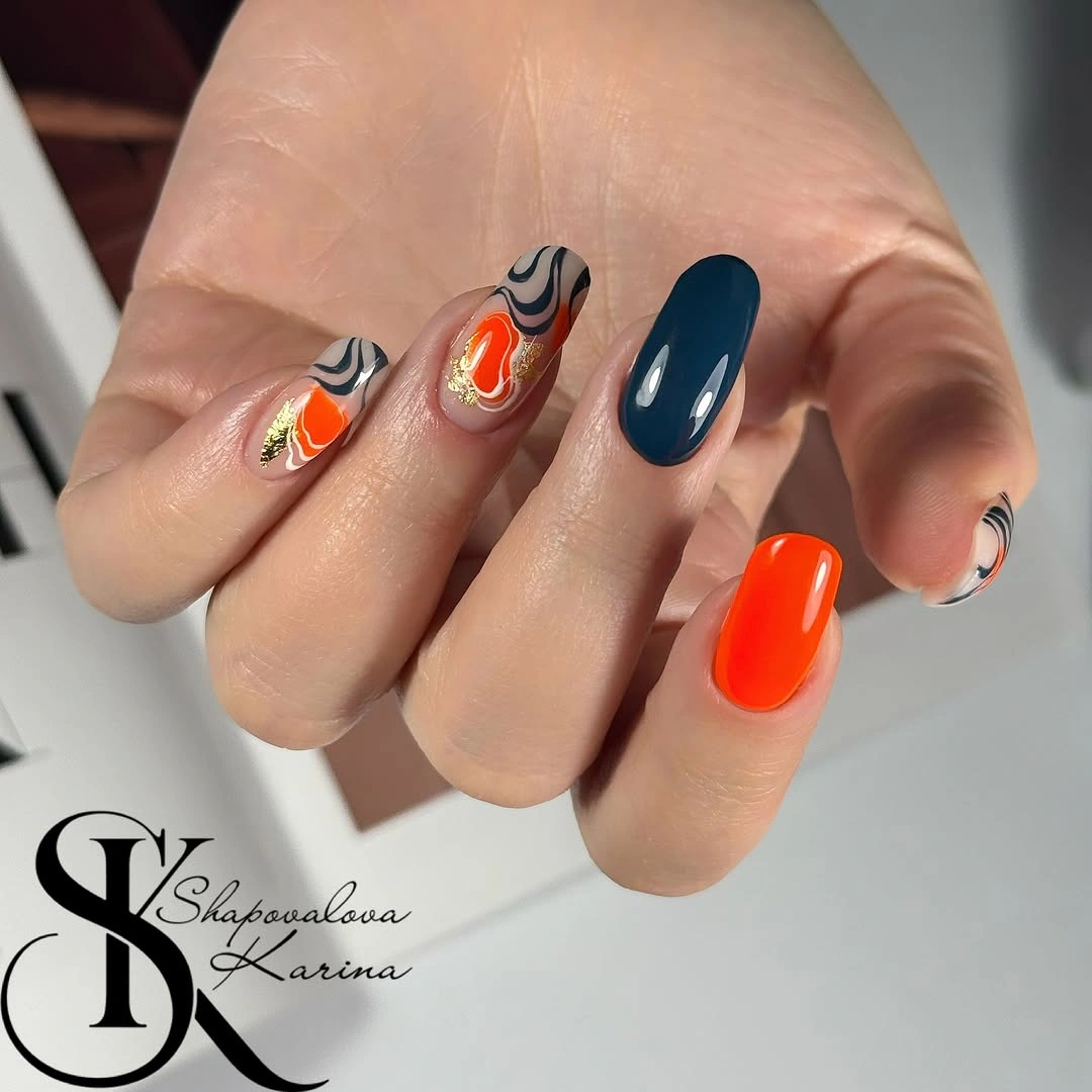 orange and teal almond nails with white black wavy accent designs