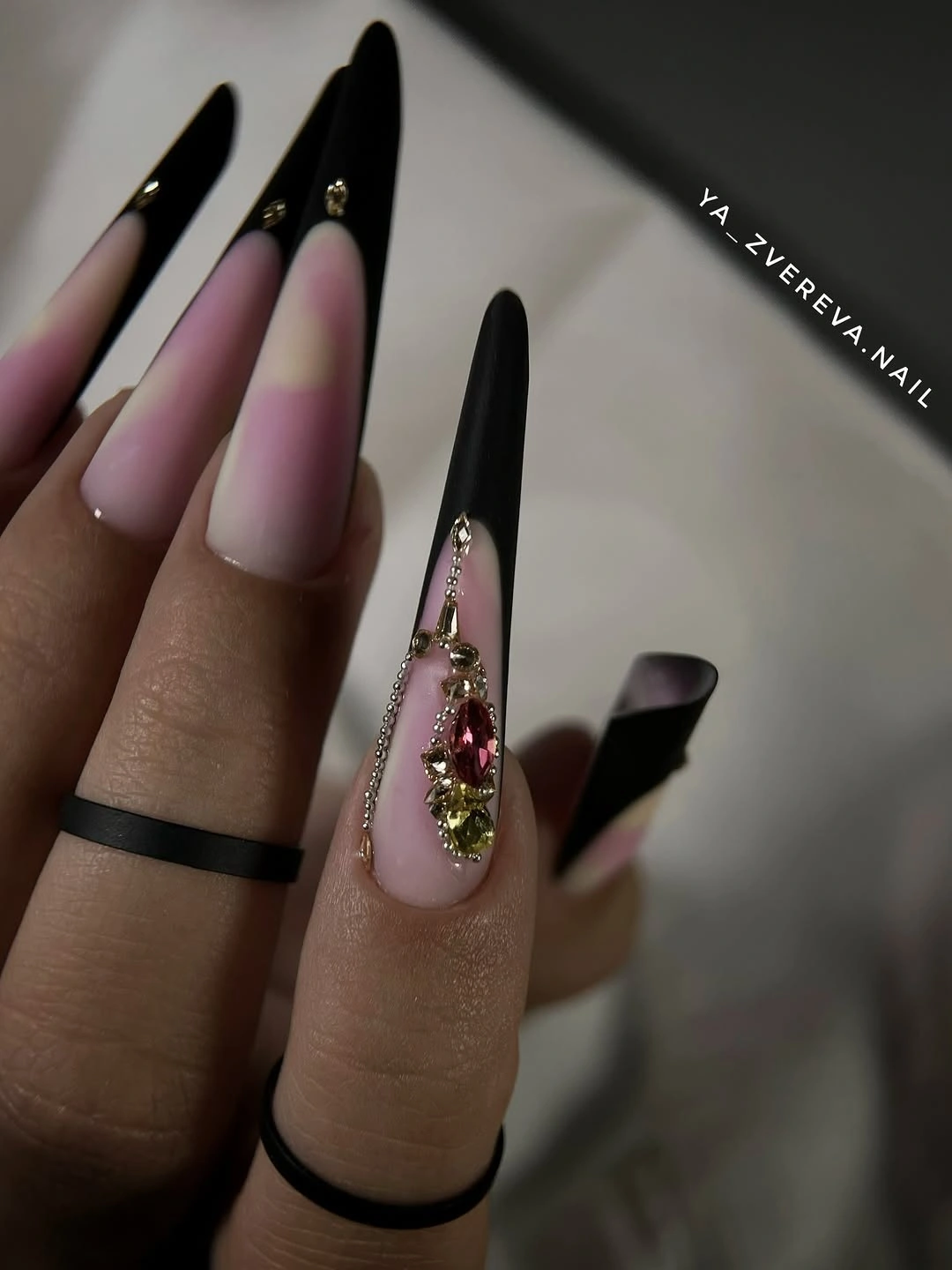 black-to-pink stiletto nails with one bright jeweled-looking detail