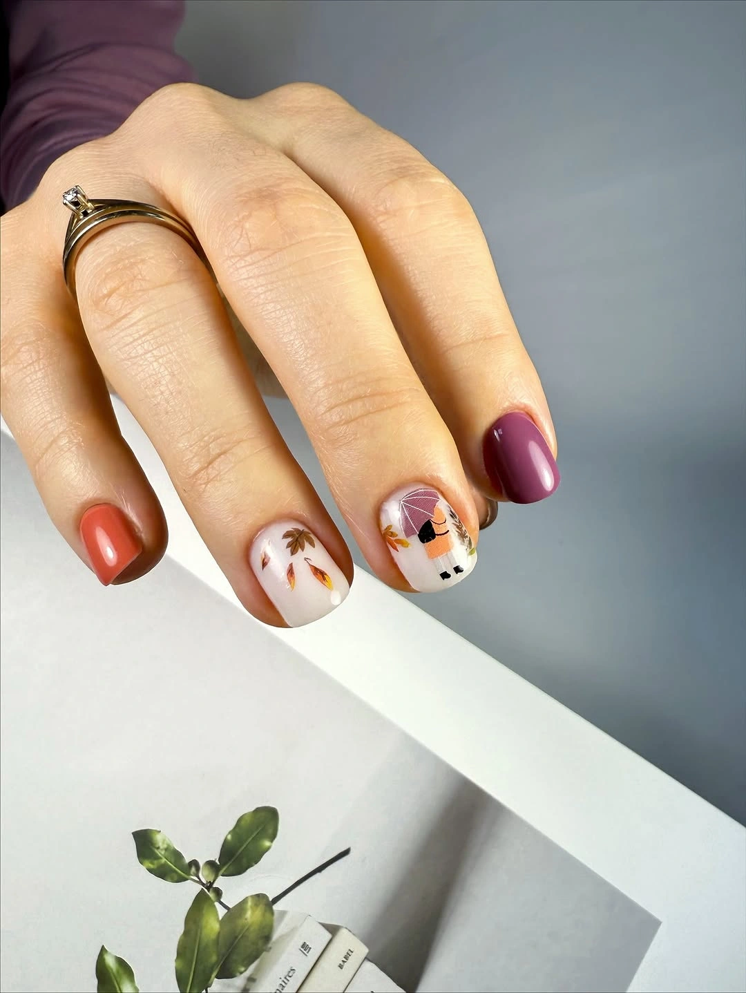 Short square nails mixing burgundy coral white and tiny fall motifs