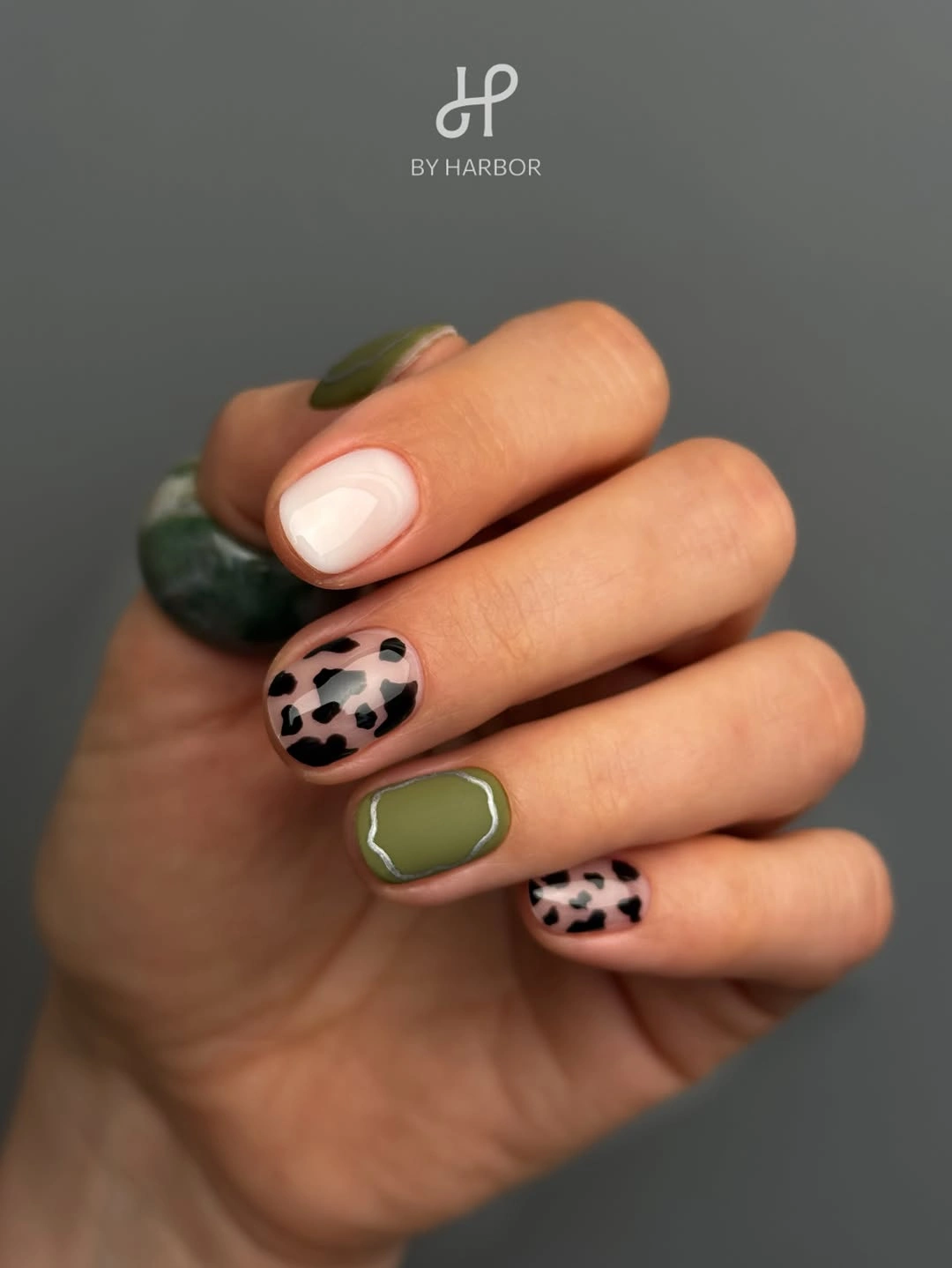 Short olive green and nude nails with black spotted accents