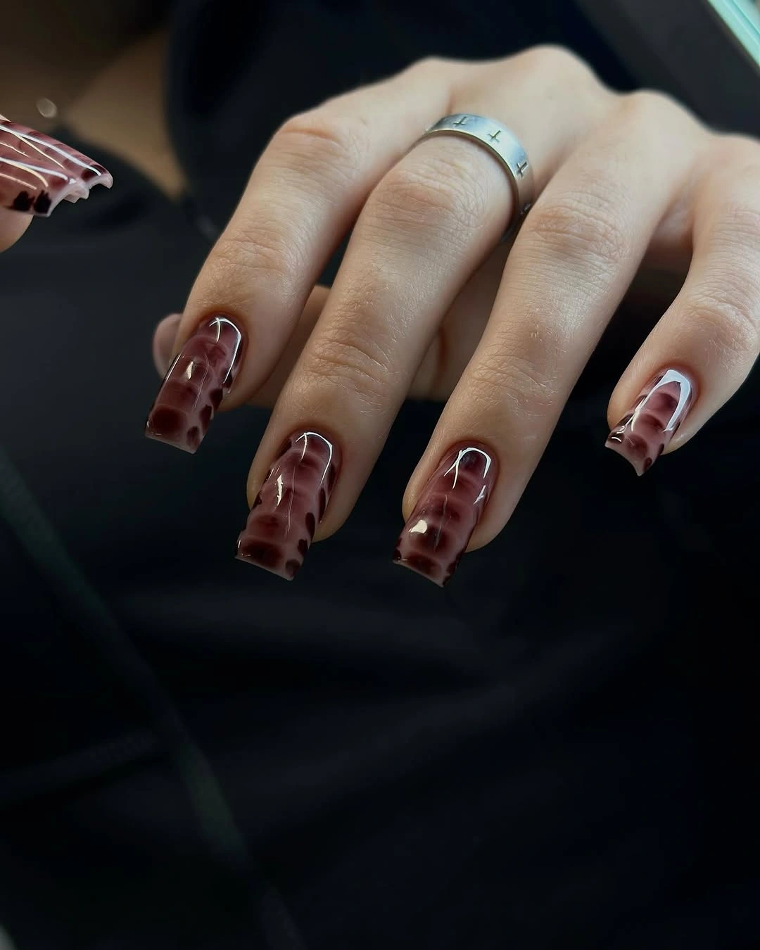 Long translucent burgundy square nails with pale curved details
