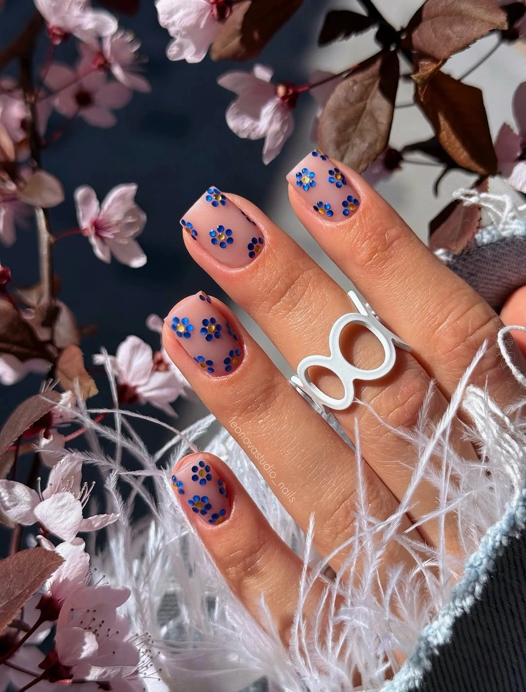 Short sheer square nails with repeated cobalt blue dot clusters