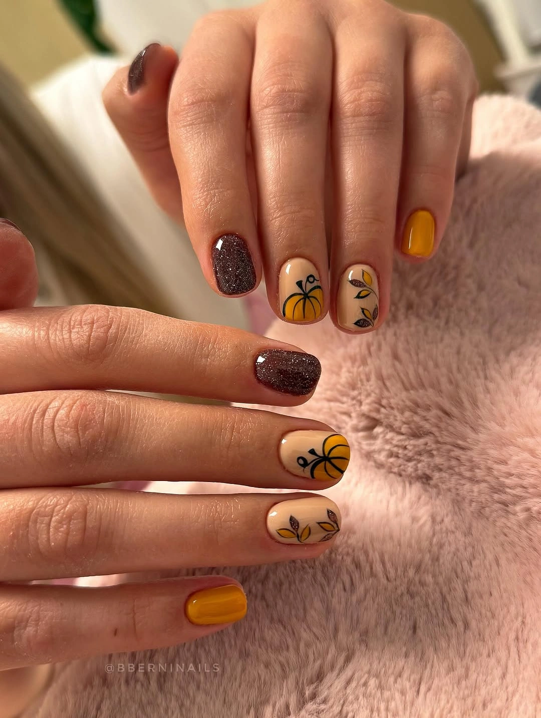 Brown and amber fall nails with glitter and a dark abstract accent motif