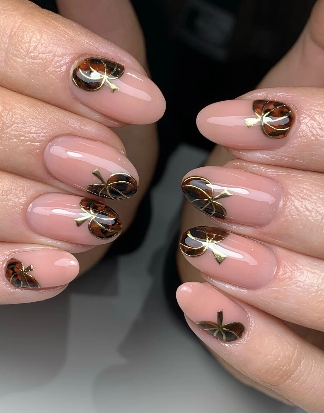 Glossy pale pink fall nails with fine brown black and gold seasonal linework