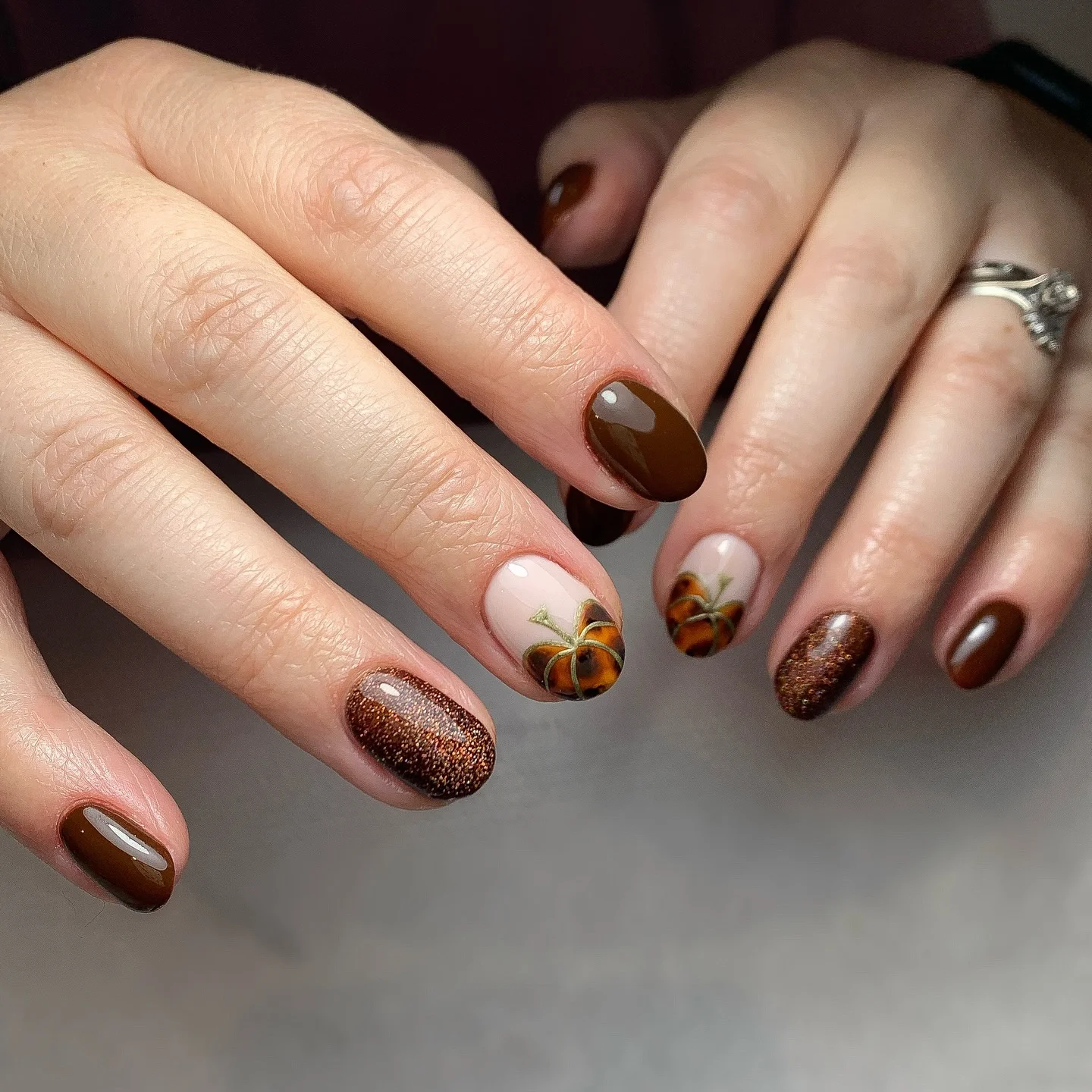 Dark brown short to medium fall nails with bronze gold pumpkin accents and glitter