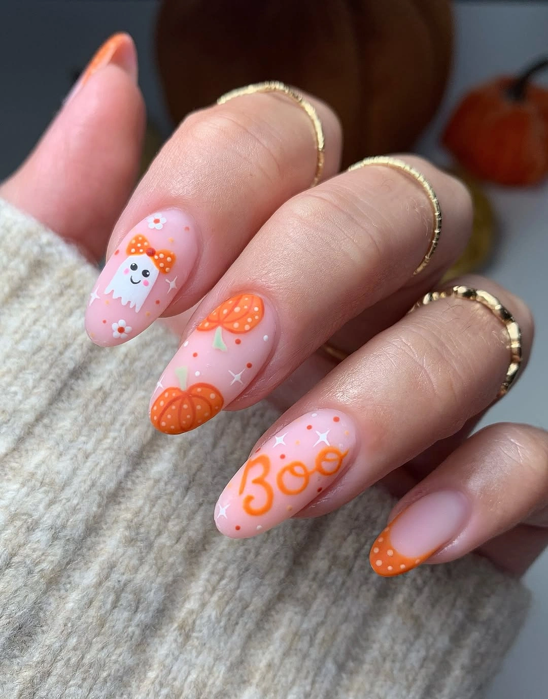 Pink almond Halloween nails with orange pumpkins, cute ghost details, and Boo lettering