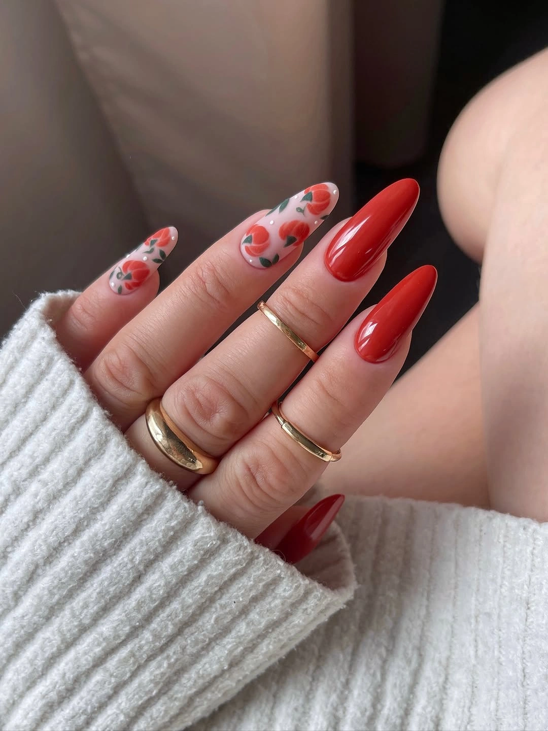 Long almond pink and orange pumpkin nails with a glossy red accent nail